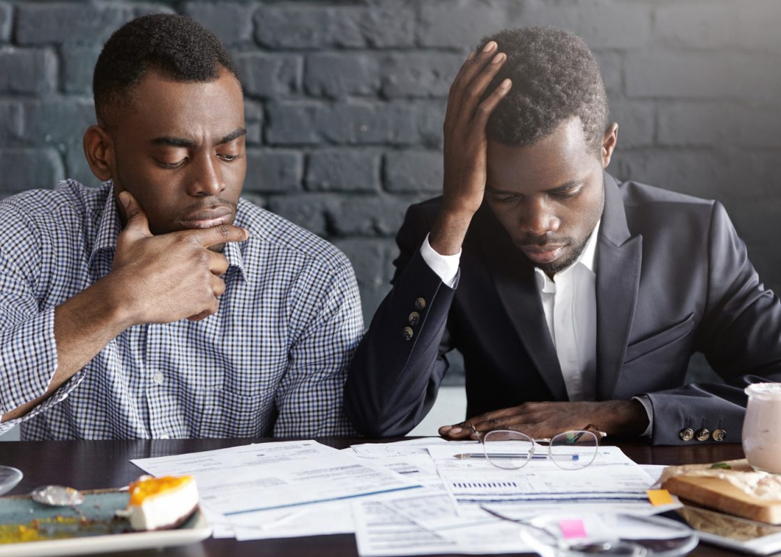 Two Tired Depressed African American Businessmen Doing Paperwork