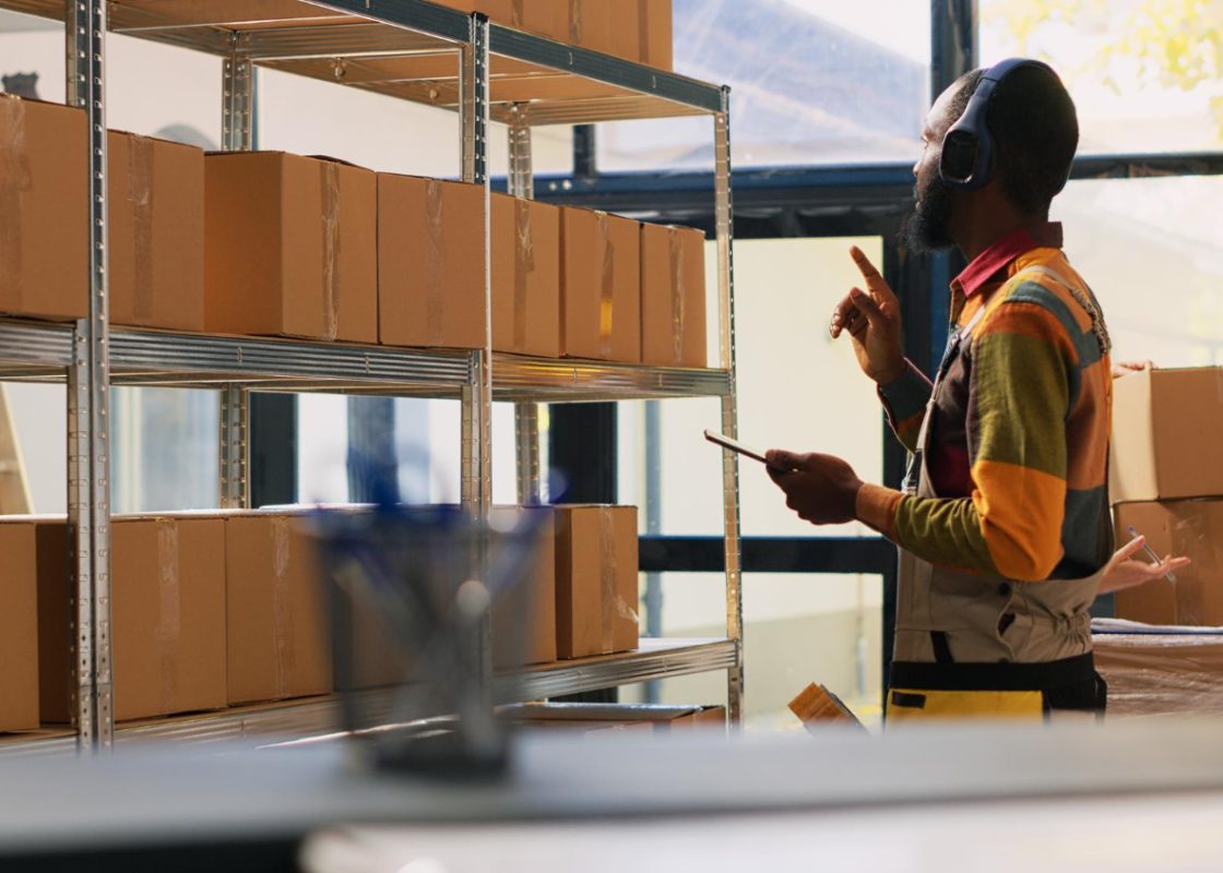 Young Worker Organizing Products Depot Listening Music Headset While He Works Quality Control Warehouse Employee Checking Logistics Tablet Retail Store Delivery